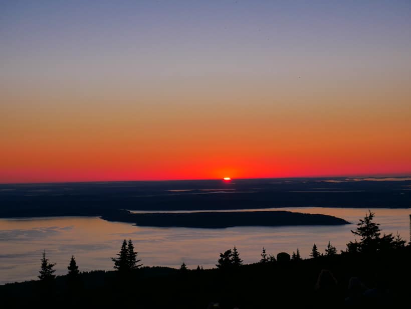Sun just peaking over the horizon at Cadillac Mountain summit.