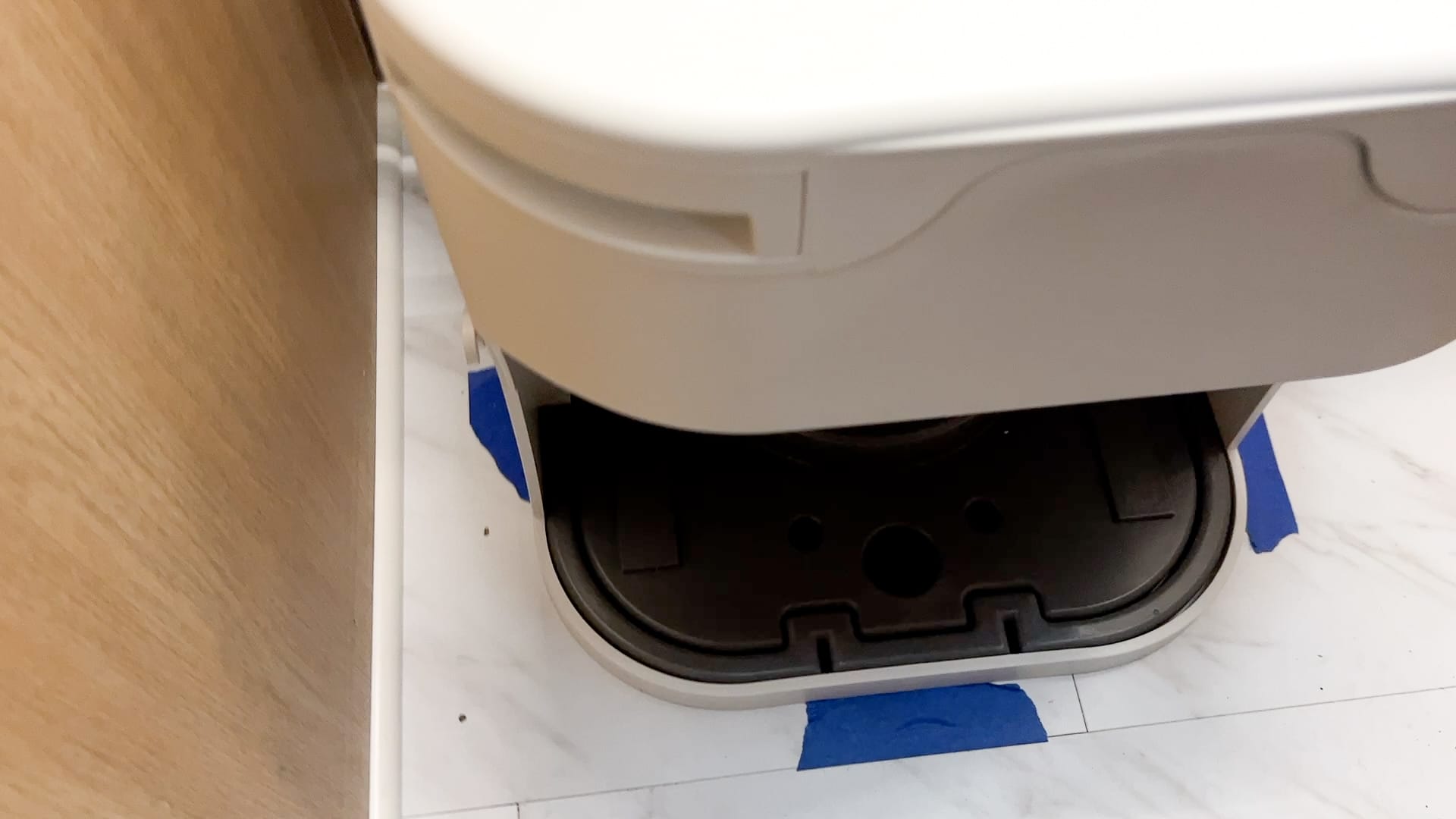 OGO Composting Toilet Installation with blue tape around edge of toilet for placement on the floor